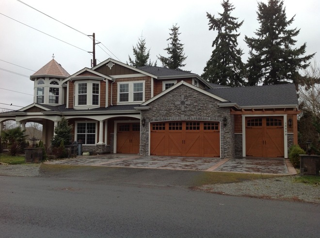 home with multiple custom wood garage doors